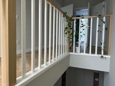 Біле поруччя на другому поверсі з видом на сходи